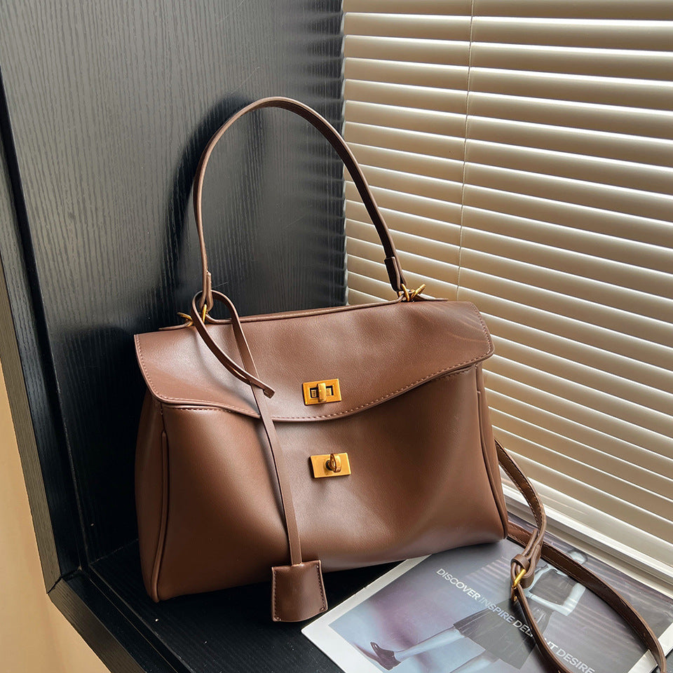 vintage chamois leather tote bag displayed against a backdrop of blinds and magazines.