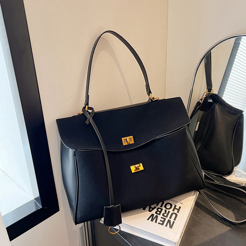 Vintage Chamois Leather Tote Bag displayed on a table near a mirror, featuring a sleek design and adjustable strap.