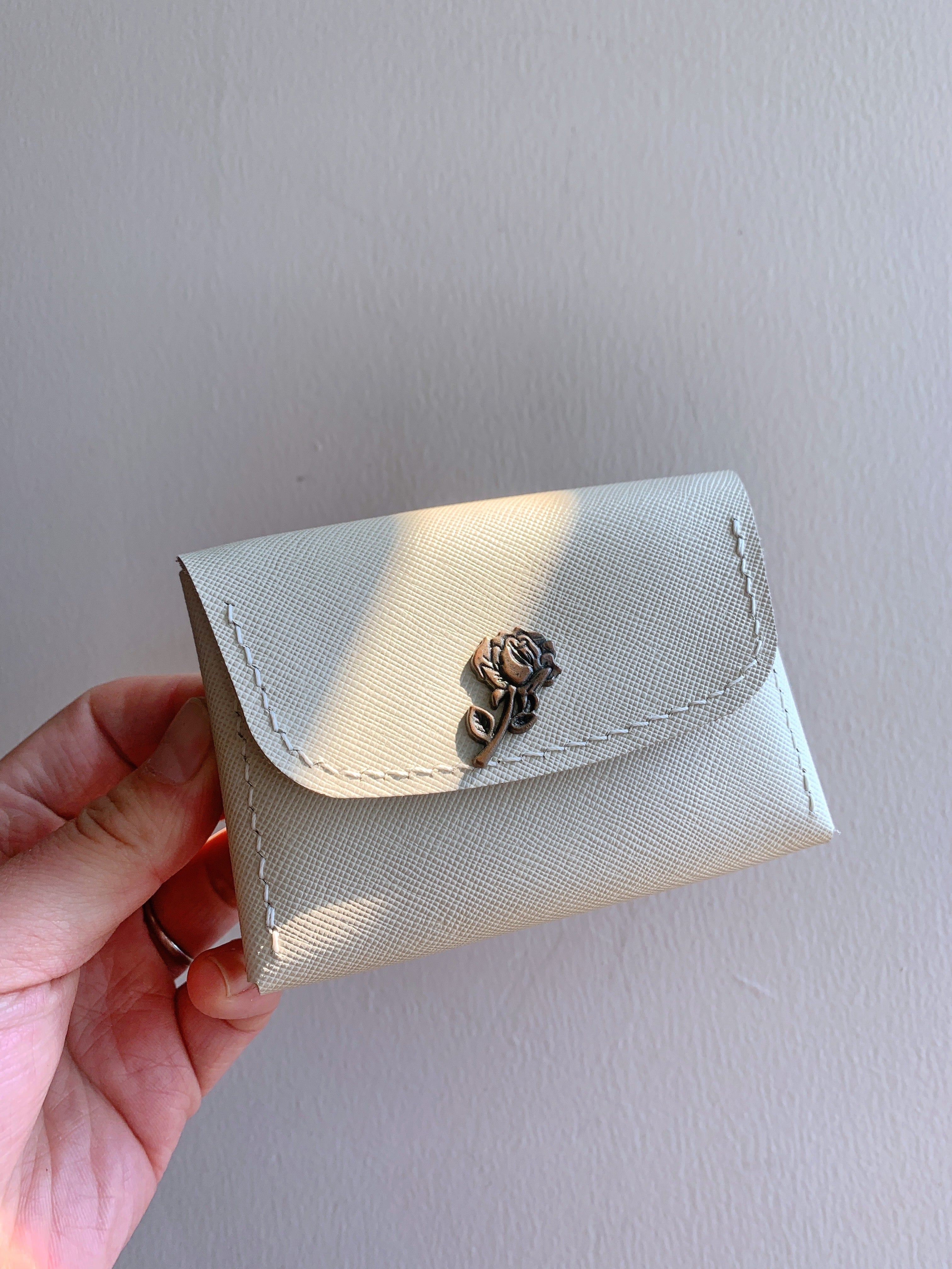 Handmade leather wallets in a minimalist design with a rose clasp, perfect for stylish organization.
