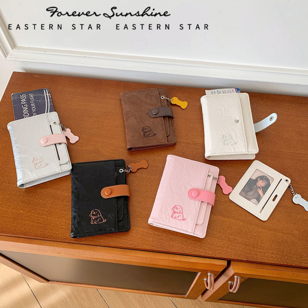 Colorful puppy passport holders in various designs and colors on a wooden table, showcasing travel organization accessories.