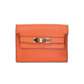 Elegant leather card bag in orange with refined hardware and meticulous stitching.