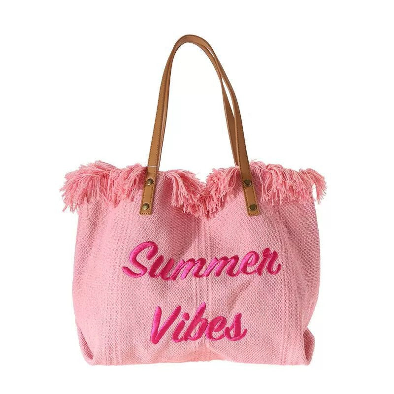 2026 Spring-Summer Series Straw Tote Bag with vibrant pink colors and fringed detailing, perfect for summer outings.