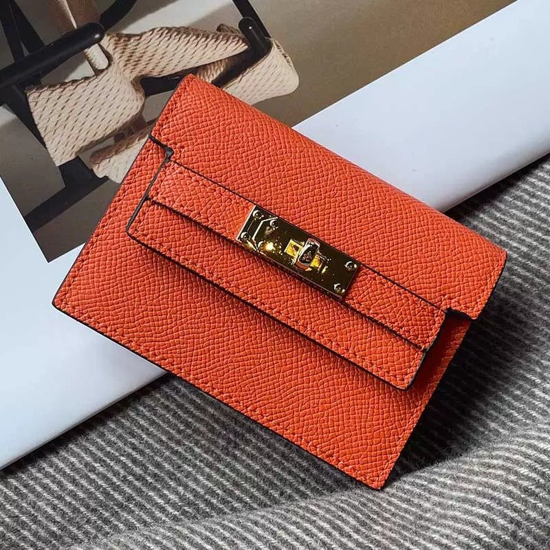 Elegant leather card bag in vibrant orange with gold clasp, showcasing premium craftsmanship and stylish design.