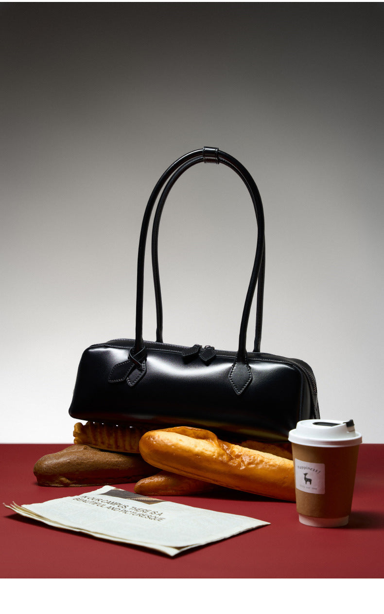 2025 Winter Leather Baguette Bag displayed with pastries and coffee, showcasing contemporary style and functionality.