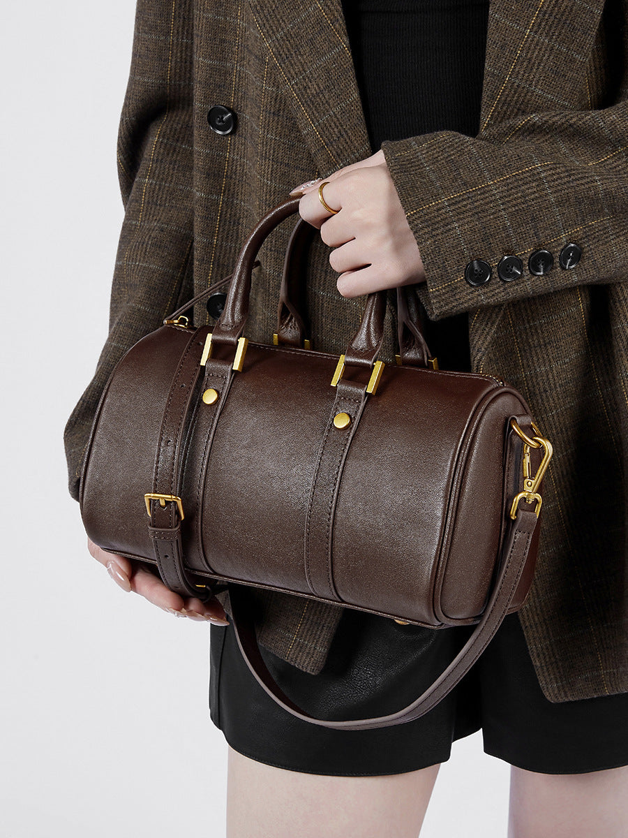 Leather vintage boston bag held by a model, showcasing its elegant design and premium full-grain leather.