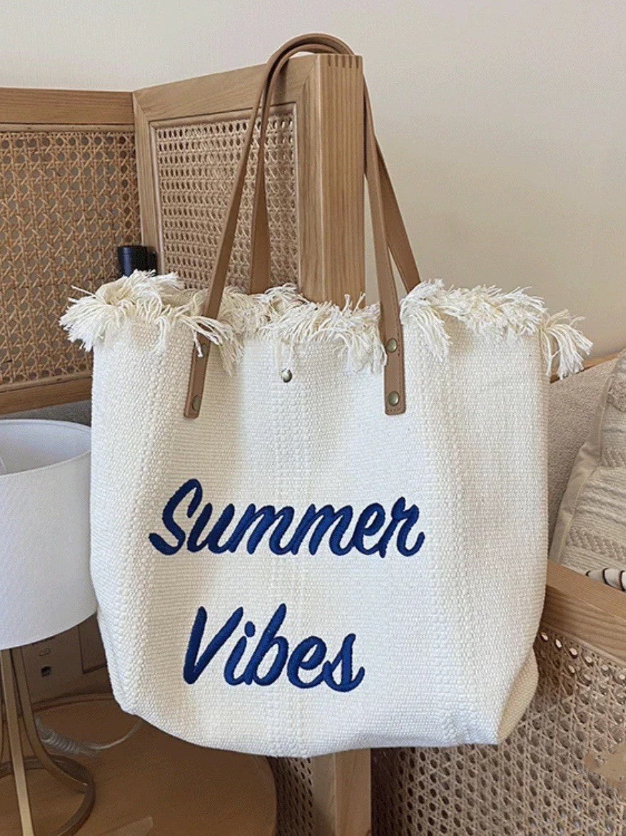 2026 Spring-Summer Series Straw Tote Bag with fringe detail and 'Summer Vibes' text on a neutral background.