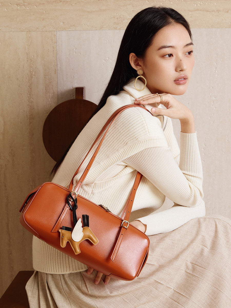 Elegant woman holding a leather bowling handbag Dreamland Series, showcasing its charm and sophisticated design.