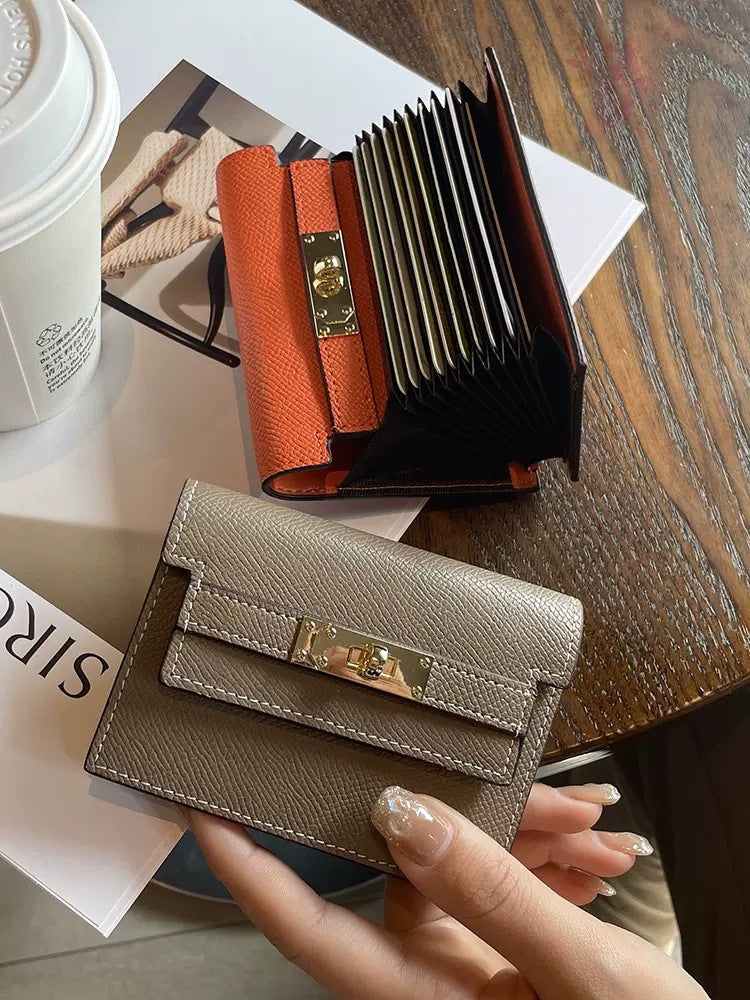 Elegant leather card bag showcased with an orange card holder on a stylish table with coffee.