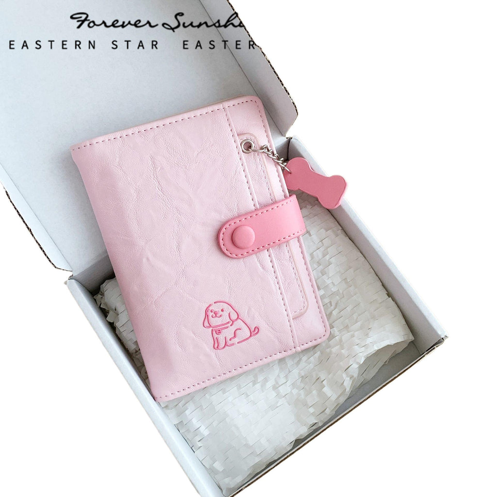 puppy passport holder in pink with puppy design inside a cardboard box