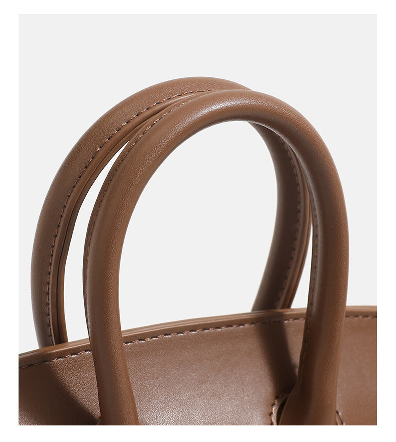 Woolen handbag for winter featuring elegant brown handles, showcasing luxurious craftsmanship and trendy design.