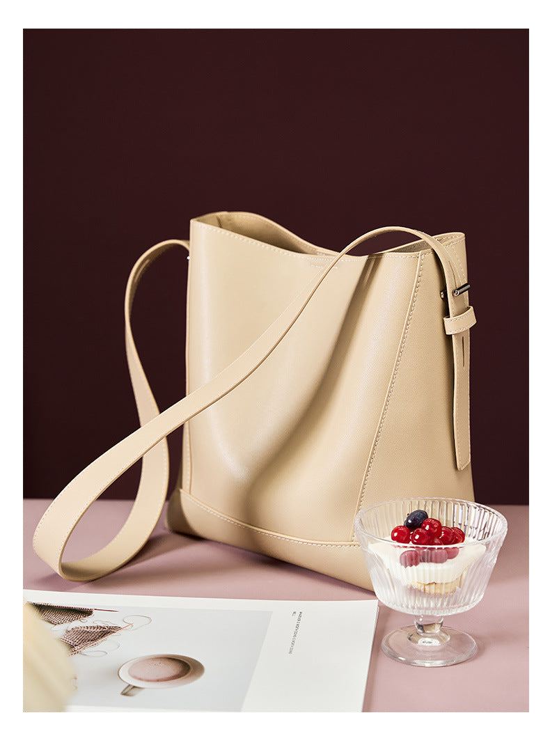 2026 genuine leather bucket bag showing premium napa leather and adjustable strap, paired with a dessert.