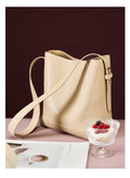 2026 genuine leather bucket bag showing premium napa leather and adjustable strap, paired with a dessert.