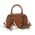 classic leather Boston bag with playful keychain accessories and a compact design.